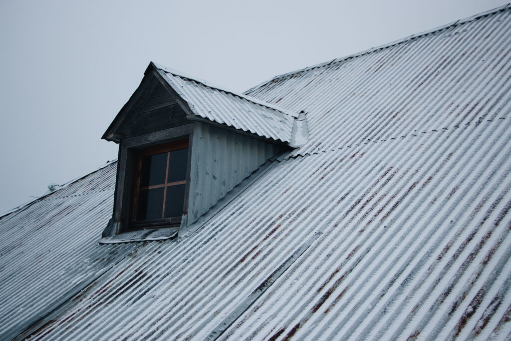 Snow-covered metal roof, showing winter performance of roofing materials and roof types