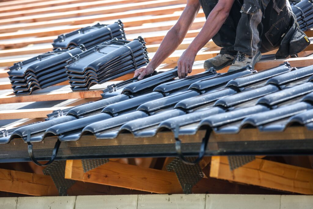  Contractor securing roof tiles on wooden frame, showing careful new roof installation process