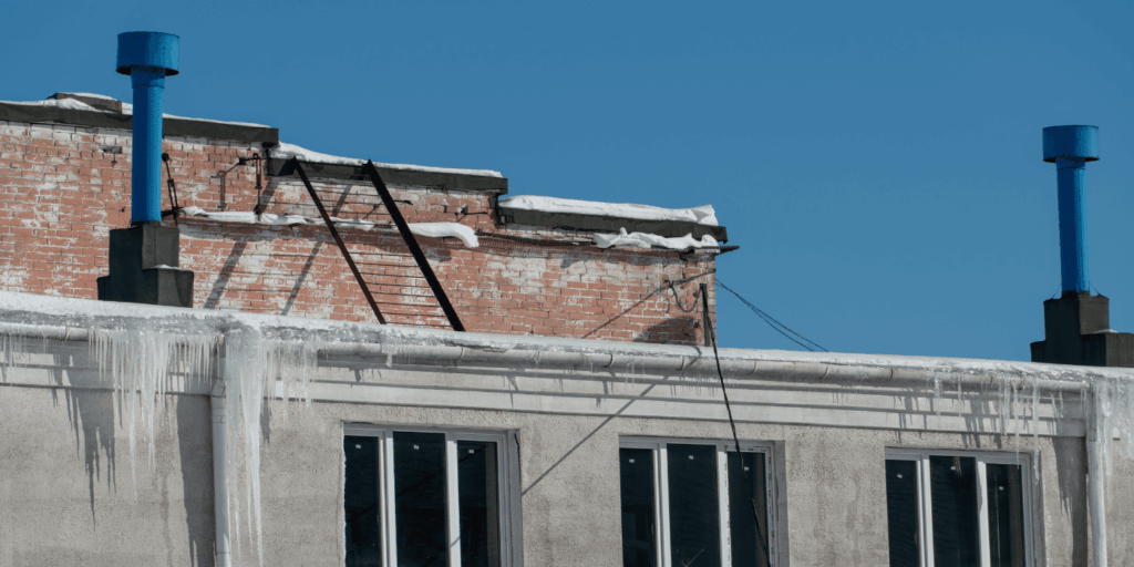 winter roof installation problems with ice dams forming on building edge due to poor roofing work