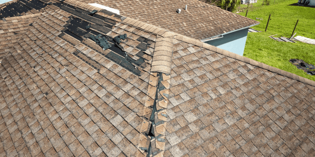 Damaged asphalt shingle roof with missing shingles along ridge needing professional roof rejuvenation