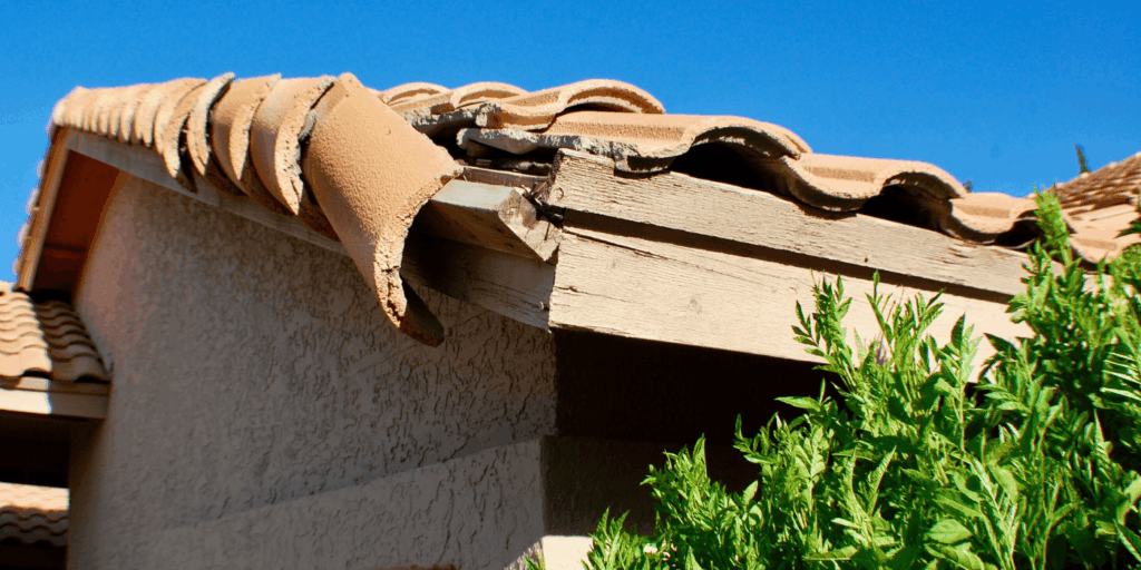 Roof leaks near damaged roof edge and cracked tiles, allowing water to enter and cause wood and wall damage