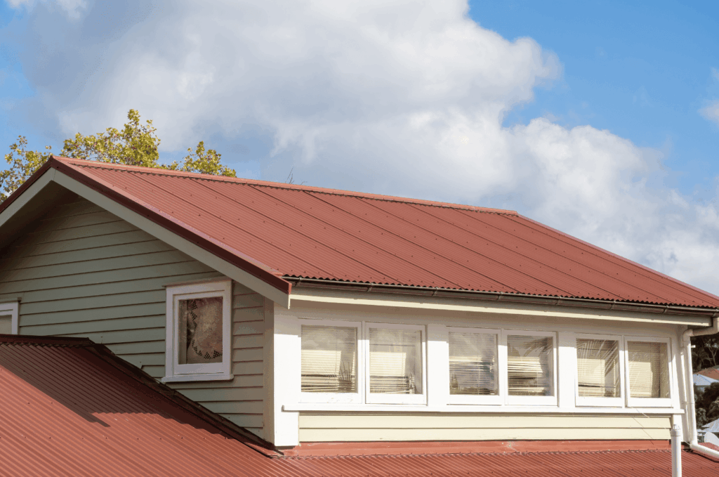 Modern home with red metal roofing, showing a durable and weather-resistant roof designed for long-lasting protection