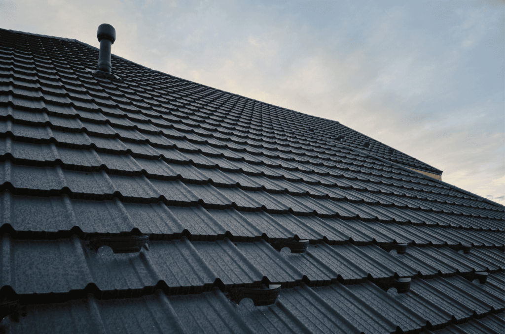 Worker heating and sealing roof material to stop roof leakage during a professional roofing repair.