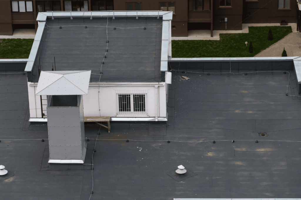 Large commercial building rooftop showing areas maintained and restored during flat roof repair.