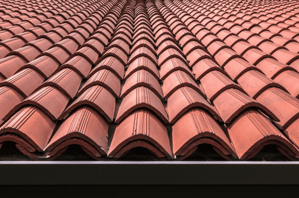 Detailed view of red tile roofing pattern with curved tiles, built to handle weather while giving the roof a classic look
