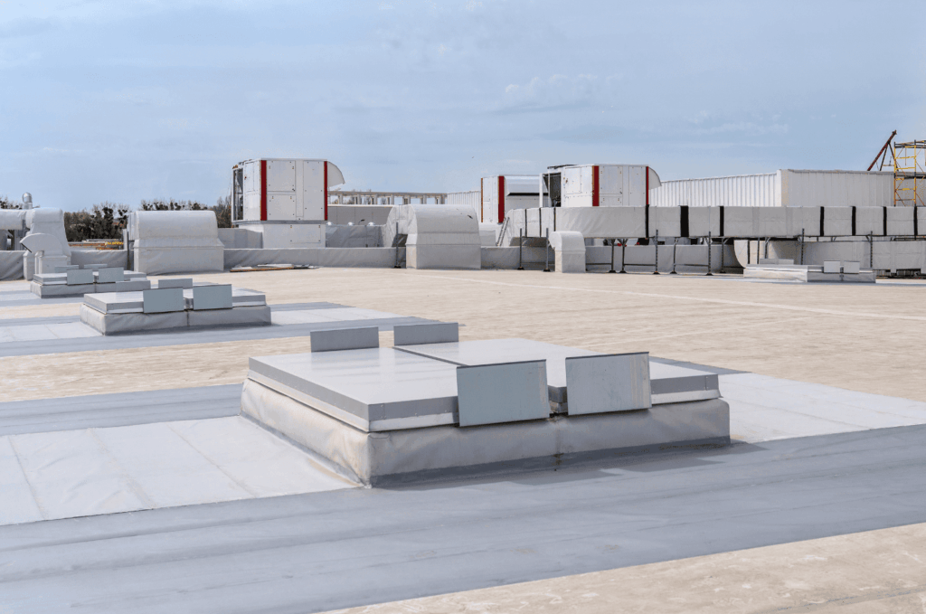 Flat commercial roof with HVAC systems and vents, showing a clean surface used for large building roofing systems