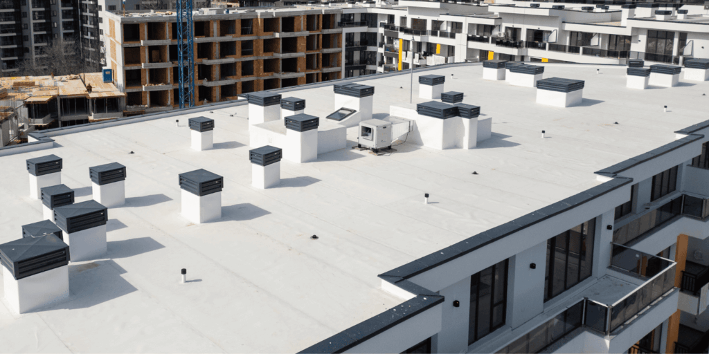 Large commercial roof on an apartment building with vents and equipment, designed for durability and easy maintenance