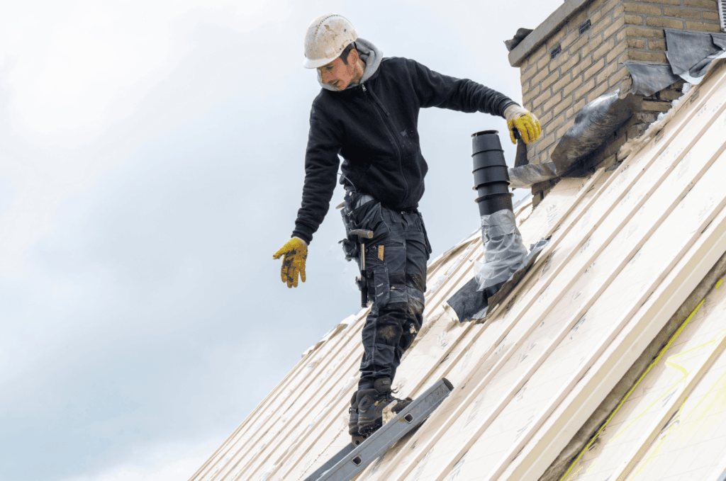 Worker performing a roof replacement and roof overlay, installing new roofing layers to improve protection and prevent leaks