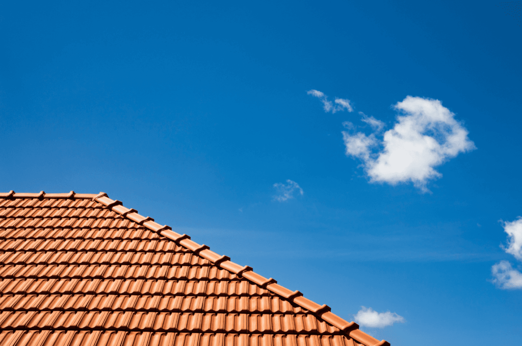 Clay tile roof against blue sky shown during a roof inspection to review tile alignment and ensure long-term roof performance