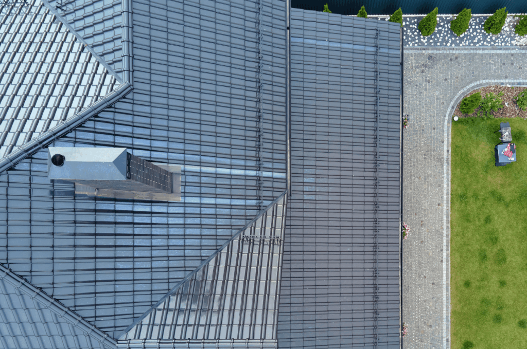 Close aerial view of roof sections and chimney captured during a drone roof inspection to monitor roof safety and wear