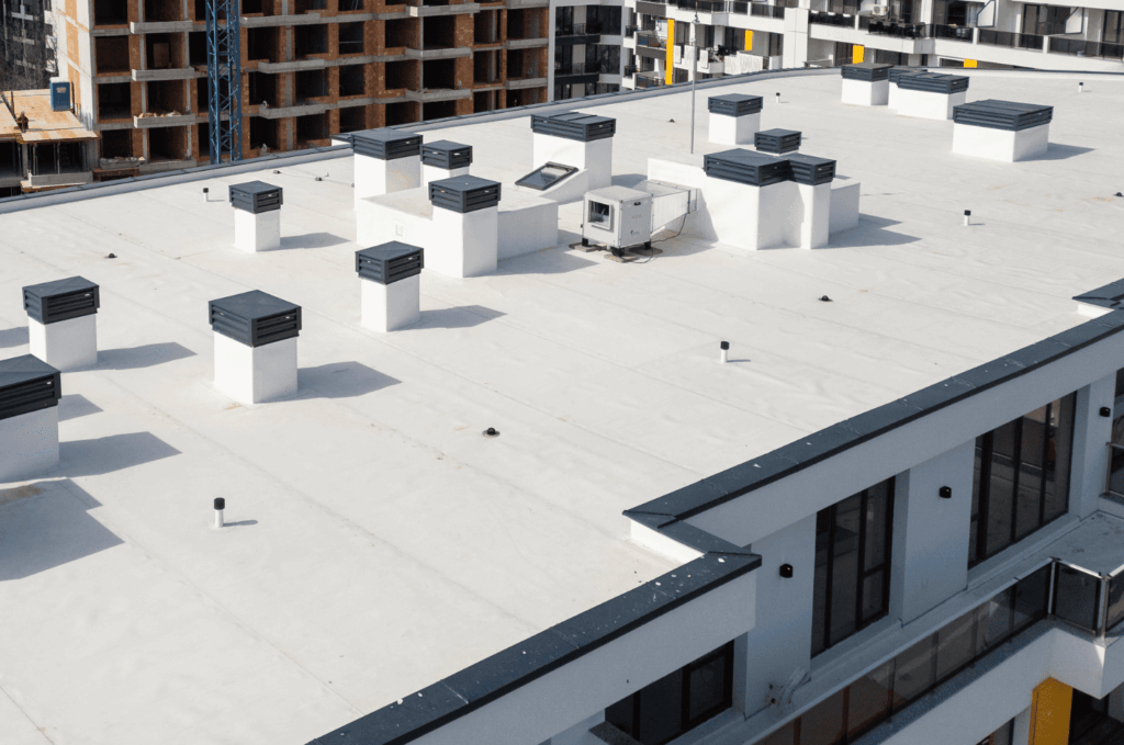 Large commercial roof on a modern building with multiple vents and equipment placed for proper airflow and safety