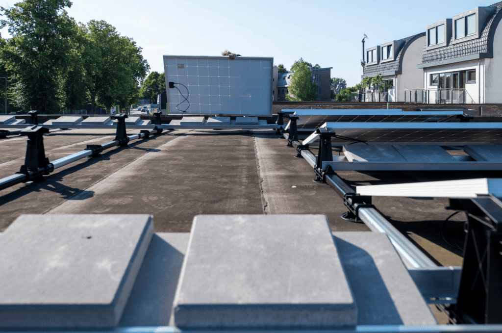 Commercial flat roof with solar panel supports and protective blocks installed to keep equipment stable and secure