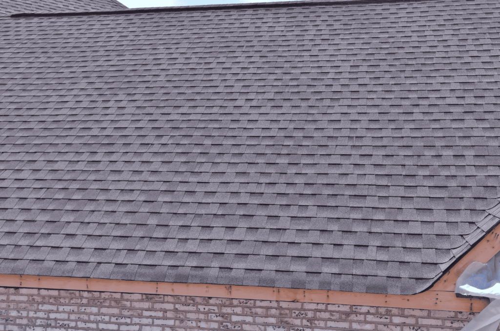 New roof installation with asphalt shingles laid evenly across the surface to create strong weather protection