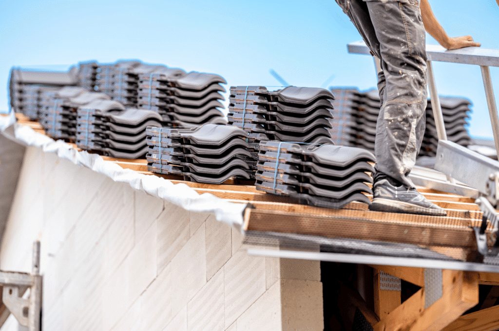 Roof installation crew preparing roof tiles and materials before completing the new residential roofing system