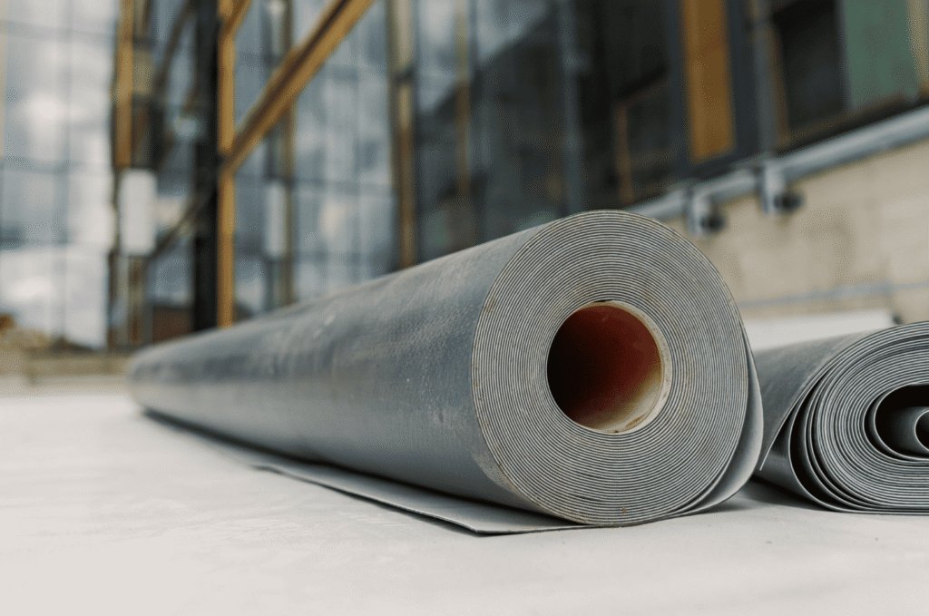 Large rolls of roof underlayment material placed on a construction site ready for commercial roofing installation work