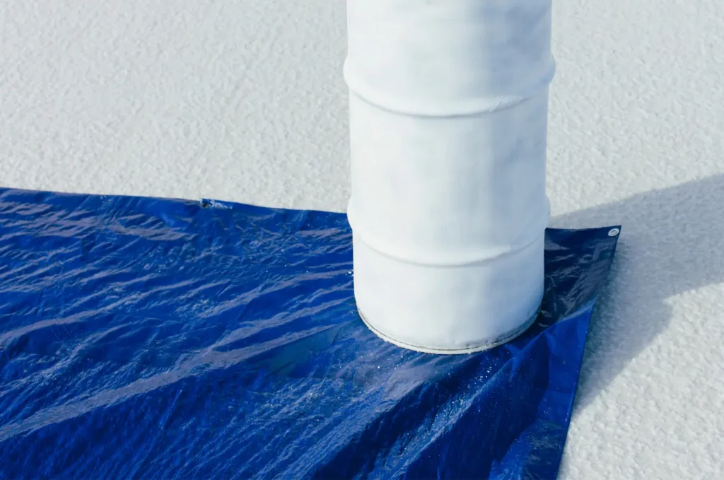 Close view of roof tarping sealed around a vent pipe to help prevent water leaks during emergency roof repairs