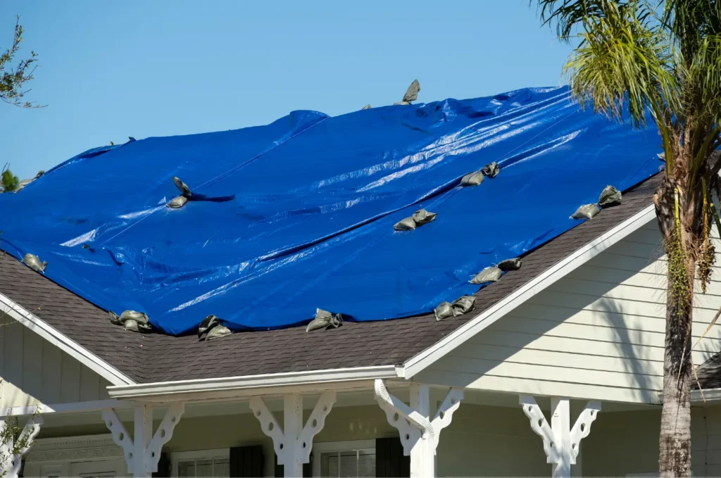 Residential home with roof tarping installed after storm damage to keep the interior dry during roof repairs