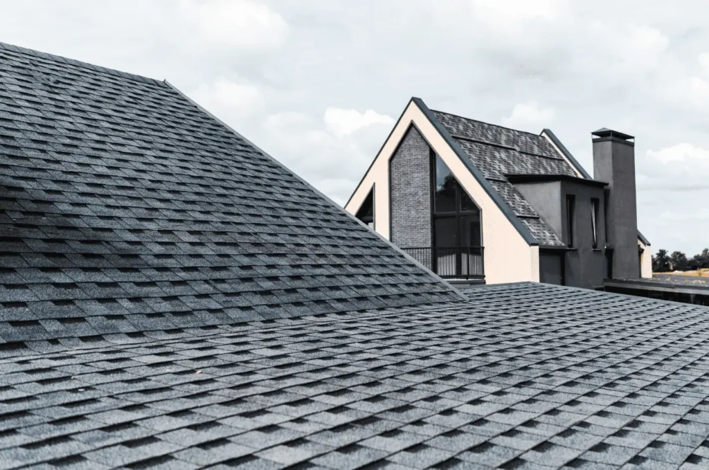 Modern home with dark shingles installed for emergency roofing protection after severe weather and roof damage