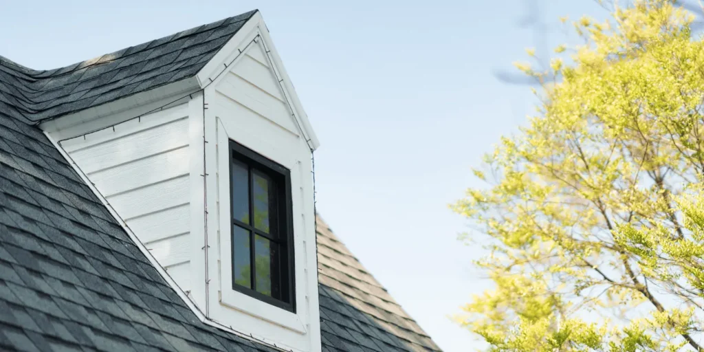 Dormer window with fresh shingles and secure emergency roofing repairs completed to prevent water intrusion