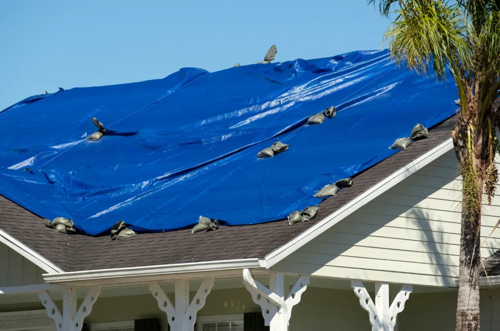 Blue roof tarp covering storm damage before permanent roof repair can begin