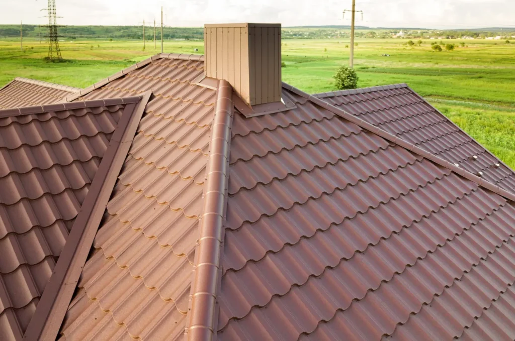 Clean metal tile roof around a chimney after professional roof cleaning to maintain curb appeal and performance