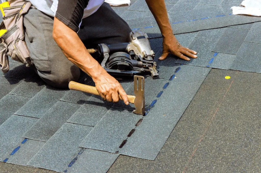 Roofing contractor replacing damaged asphalt shingles during a shingles repair to help prevent leaks and extend roof life