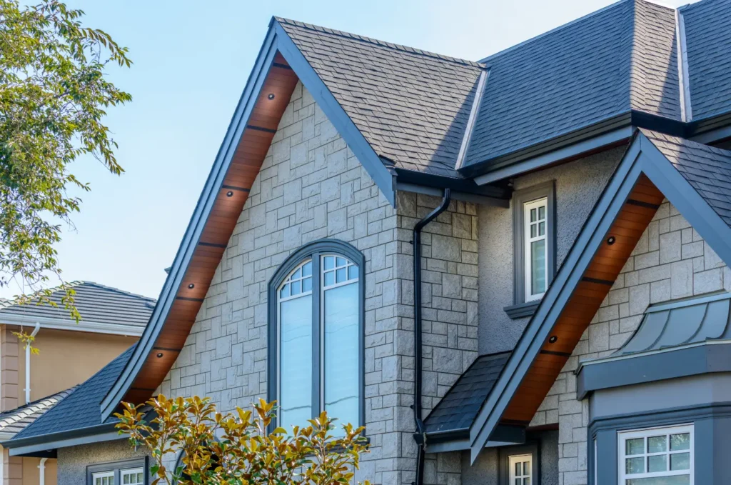 Durable architectural shingles on a blue home, demonstrating how quality materials can help extend roof life.