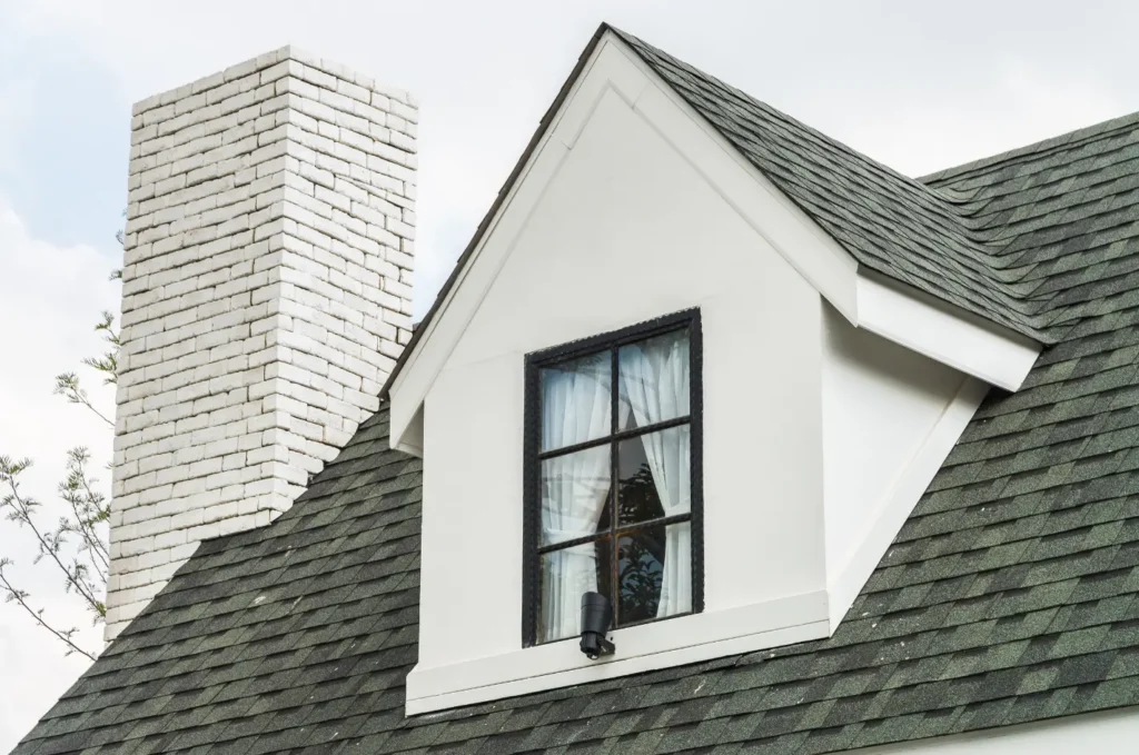Home roof with a dormer and chimney, areas often inspected during roof damage repair after storms or aging shingles