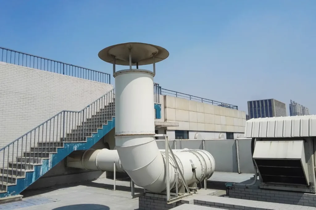 HVAC equipment mounted on a commercial roof above a large business building