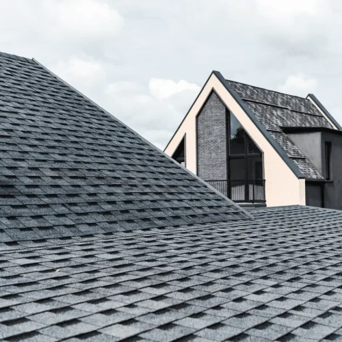 Modern home with dark shingles installed for emergency roofing protection after severe weather and roof damage